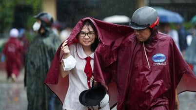 Los padres esperan bajo la lluvia a que sus hijos terminen las matemáticas para el examen de graduación de secundaria de 2025.